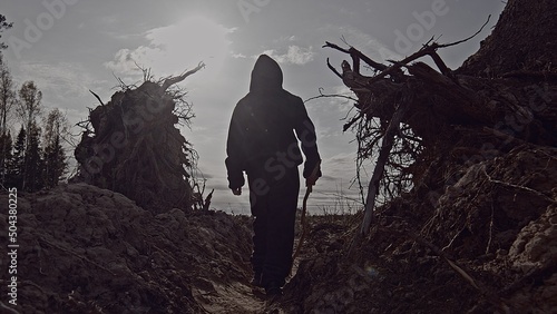 A boy walks among cut down trees. Russia.