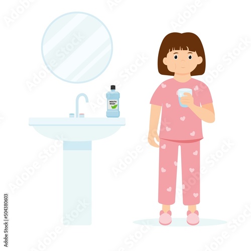 Little girl in pajamas gargles using mouthwash from a glass. Daily oral hygiene
