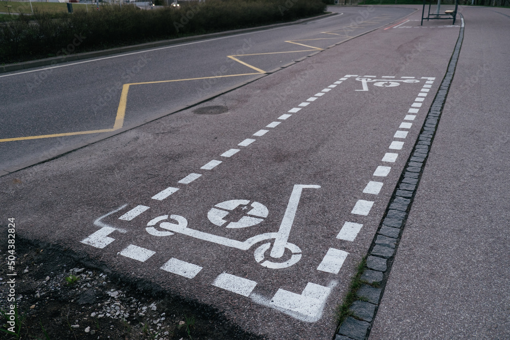 Fototapeta premium Dedicated electric scooter parking spot sign spray painted on city sidewalk. Electric scooters parking area.