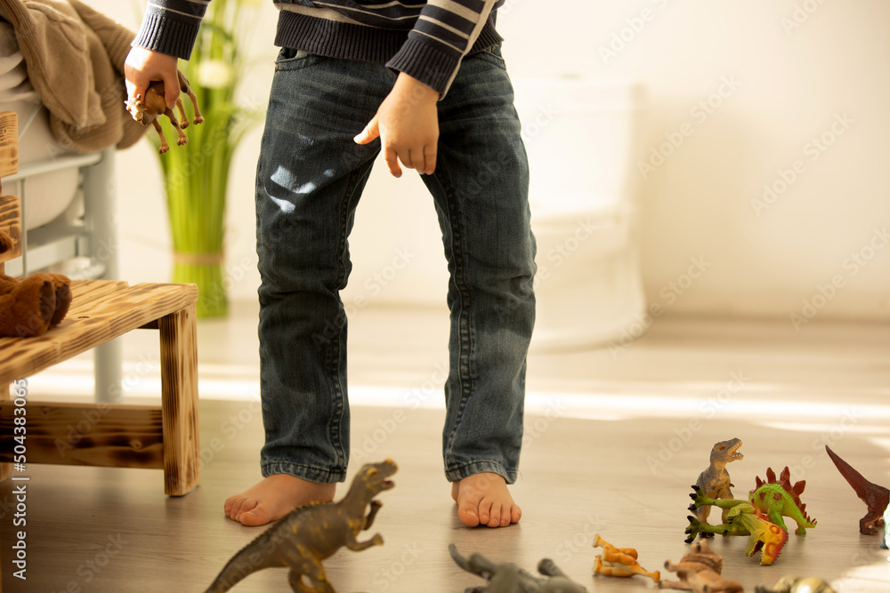 Little toddler child, boy, pee in his pants while playing with toys