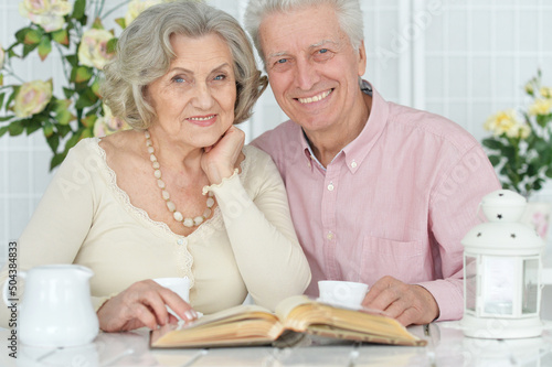 Portrait of happy senior couple reading book