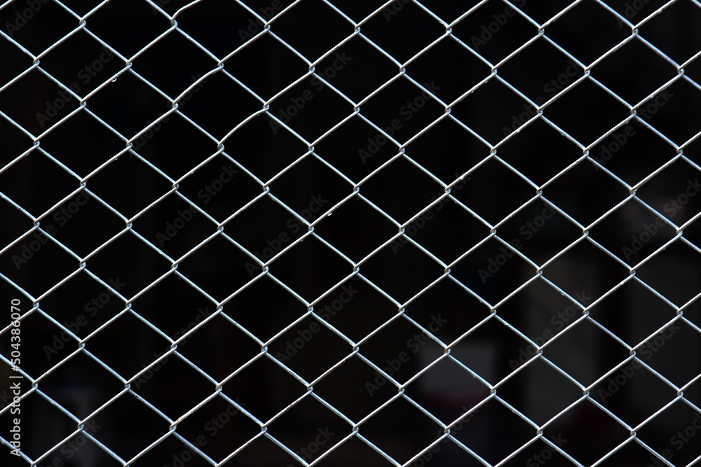 Close up metal net fence in square shape with abstract dark background can be use for security company product advertisement website template and content creator Close up metal net fence in square shape with abstract dark background can be use for security company product advertisement website template and content creator
