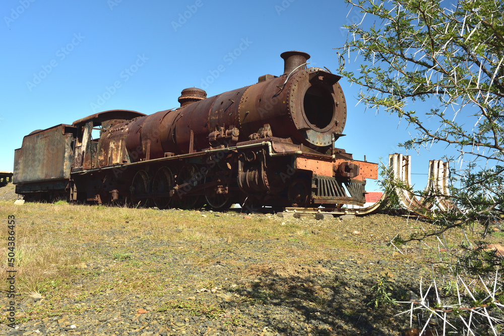 An old rusted steam locomotive that is parked in its last resting place An old rusted steam locomotive that is parked in its last resting place