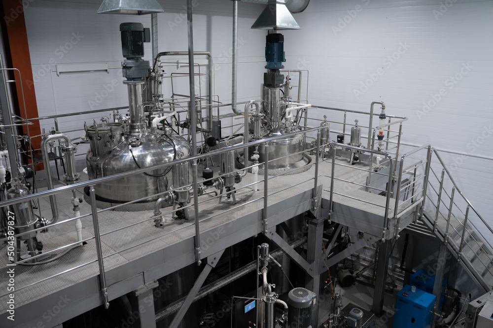 Industrial stainless steel vats. Factory interior, steel pipelines, tubes. Equipment for the production of organic fertilizers. Large reservoirs or tank Industrial stainless steel vats. Factory interior, steel pipelines, tubes. Equipment for the production of organic fertilizers. Large reservoirs or tank