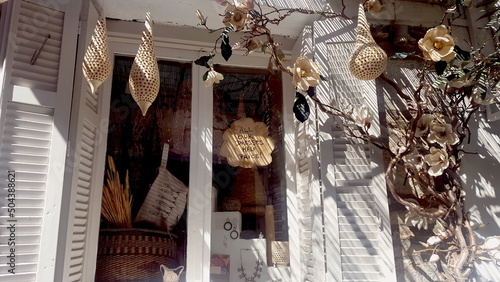Fototapeta Naklejka Na Ścianę i Meble -  Colorful decorations of Greek shops on the streets in the national style on the island of Skiathos, Greece. The photo was taken in the afternoon in hot weather in the middle of a narrow hole from the 