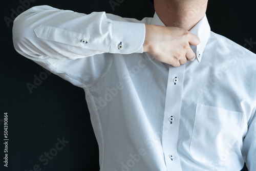 Businessman unfasten the top button of his shirt
