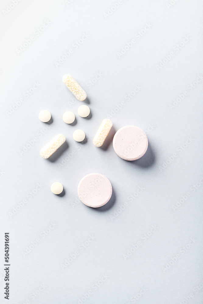 Collagen effervescent Tablets and Vitamin C tablets and capsules. Supplements to support collagen production. Bright paper background. Soft focus. Top view. Close up. Copy space. Collagen effervescent Tablets and Vitamin C tablets and capsules. Supplements to support collagen production. Bright paper background. Soft focus. Top view. Close up. Copy space.