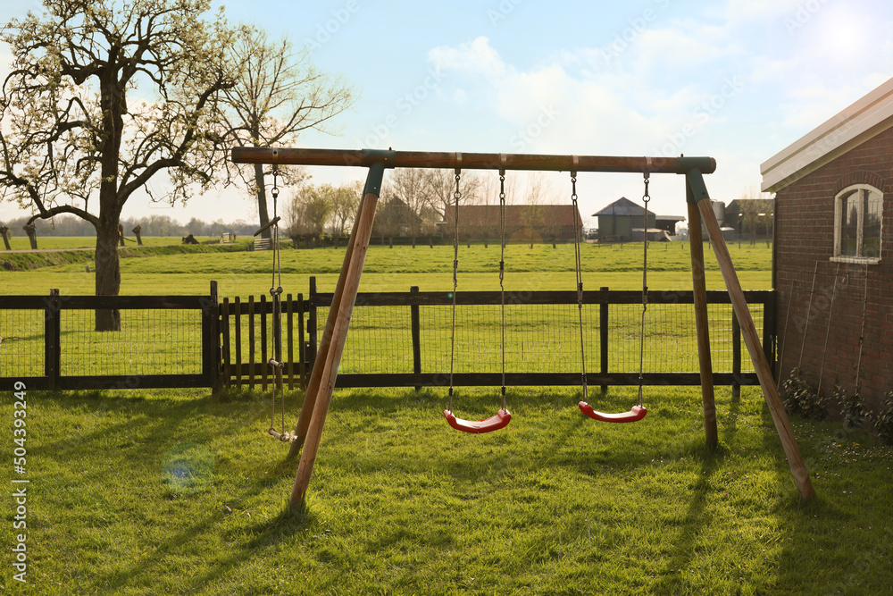 Outdoor swings near building on spring day