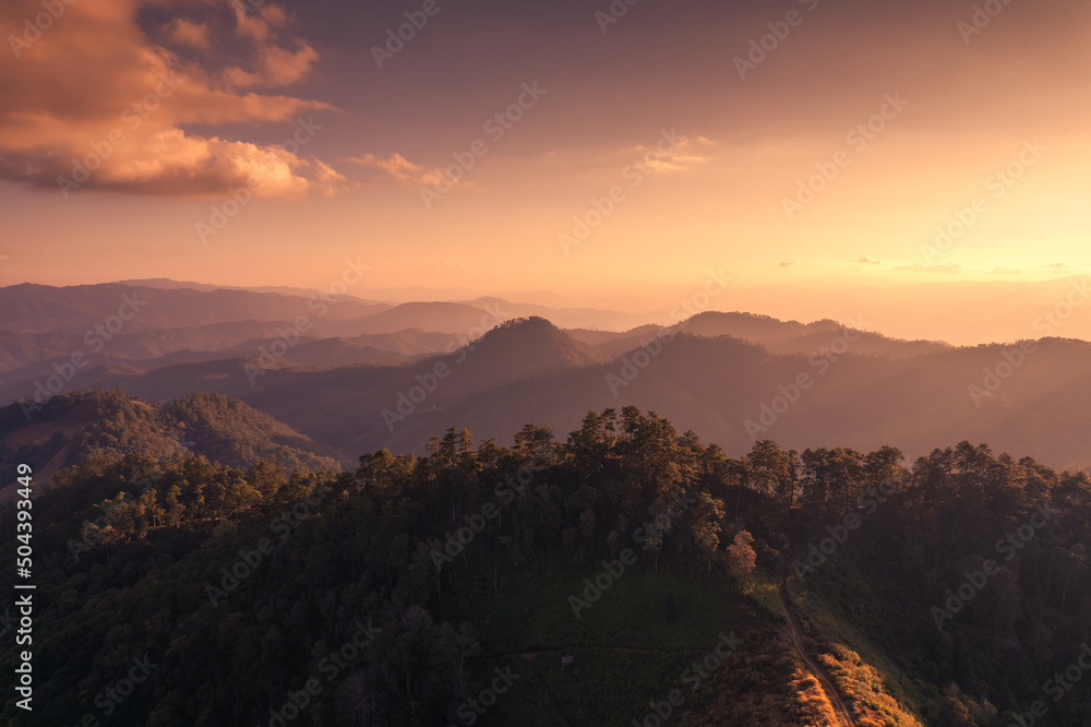 Aerial view of beautiful sunset over mountain range in tropical rainforest on faraway countryside at national park