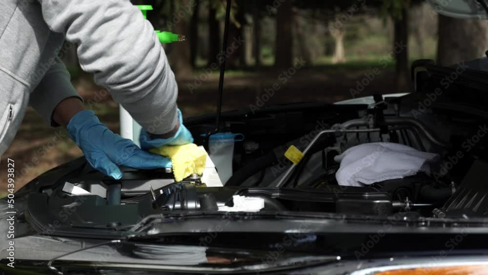 Close up of a women hand washing and wiping the car with cloth. Vehicle wash and cleaning the car engine compartment or car detailing services concept. Close up of a women hand washing and wiping the car with cloth. Vehicle wash and cleaning the car engine compartment or car detailing services concept.