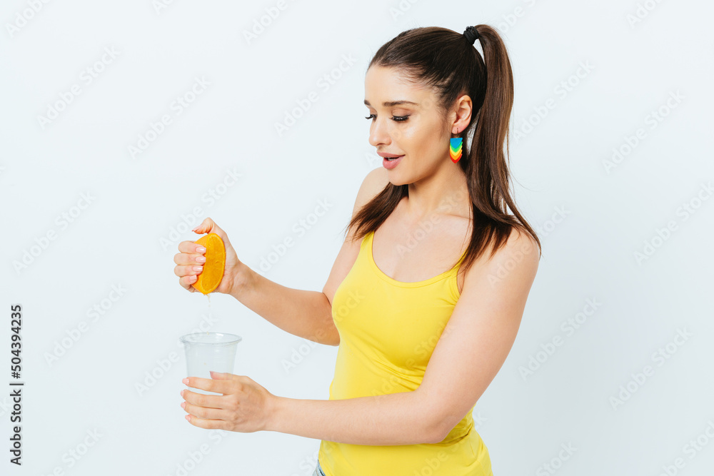 Young smiling woman squeezing juice from orange Young smiling woman squeezing juice from orange