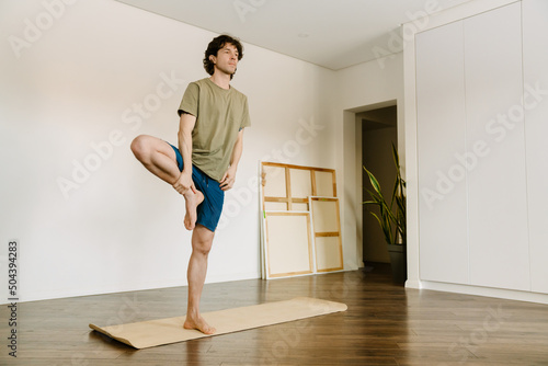 White man wearing shorts doing exercise during yoga practice