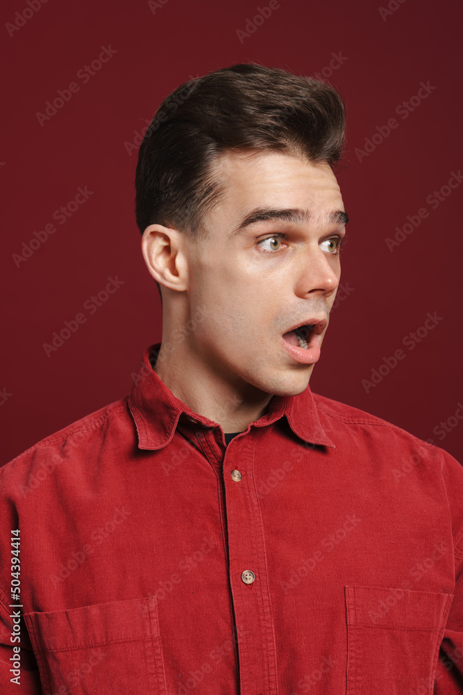 Young white man wearing shirt expressing surprise at camera Young white man wearing shirt expressing surprise at camera