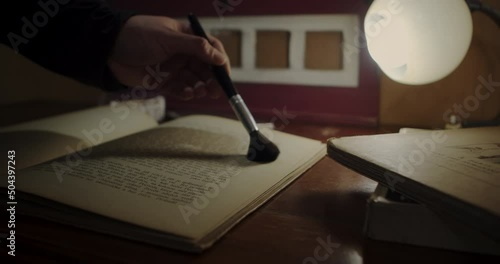 Antiquarian bookshop. Cleaning a rare book from dust