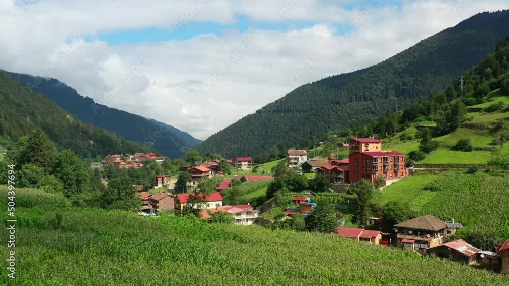aerial drone flying over a hill revealing a mountain village during a summer morning in Uzungol Trabzon Turkey surrounded by a mountainous forest and hotels aerial drone flying over a hill revealing a mountain village during a summer morning in Uzungol Trabzon Turkey surrounded by a mountainous forest and hotels