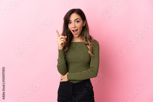 Young caucasian woman isolated on pink background intending to realizes the solution while lifting a finger up © luismolinero
