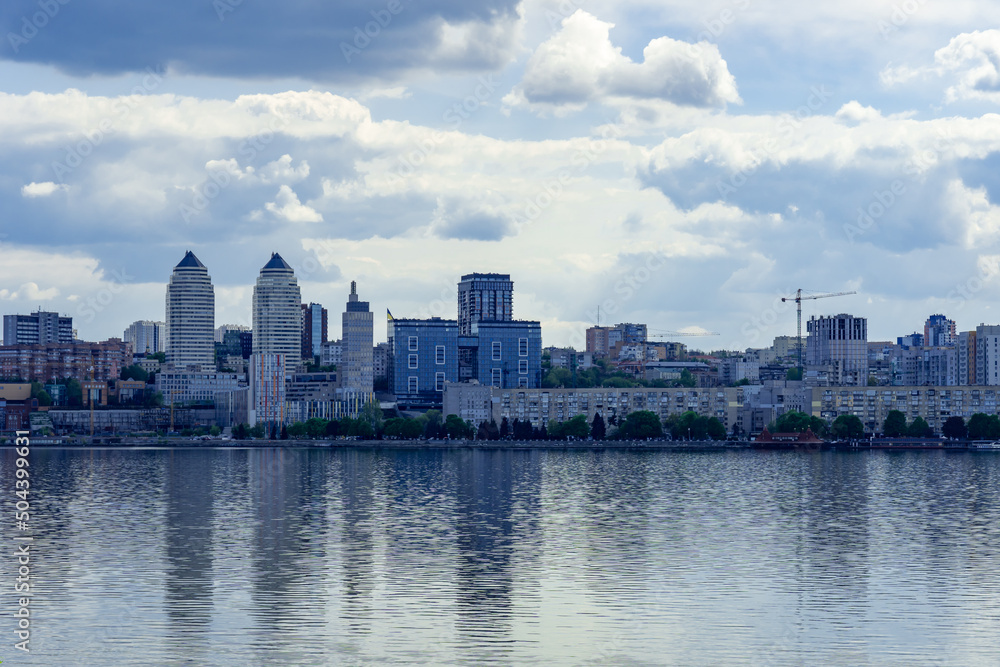 Panoramic view on the central part Dnipro city and river bank in the Ukraine. Urban landscape with shopping centers, business offices and high-rise apartments. Beautiful embankment against the sky. 