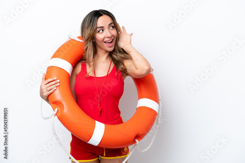 Lifeguard caucasian woman isolated on white background listening to something by putting hand on the ear