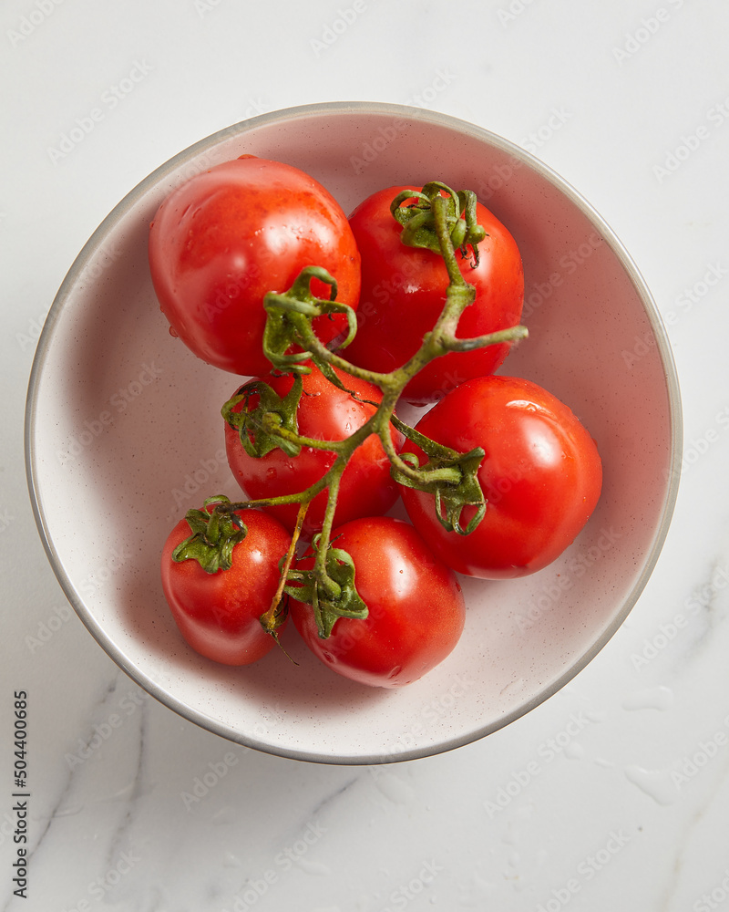 Overhead view of fresh tomato in white bowl Overhead view of fresh tomato in white bowl