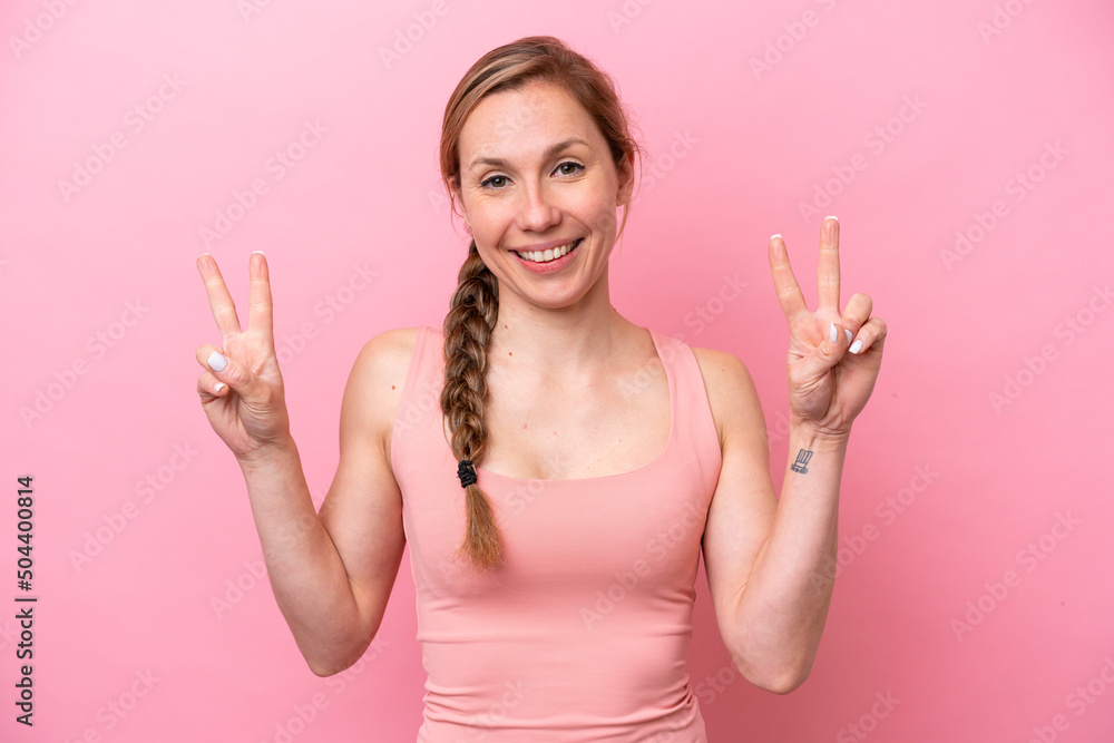 Young caucasian woman isolated on pink background showing victory sign with both hands Young caucasian woman isolated on pink background showing victory sign with both hands