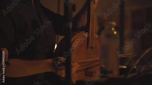Close up of artist playing traditional Turkish spike fiddle from middle eastern times. photo