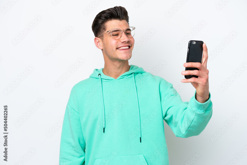 Young handsome caucasian man isolated on white bakcground making a selfie Young handsome caucasian man isolated on white bakcground making a selfie