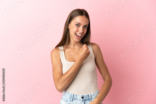 Young woman over isolated pink background celebrating a victory