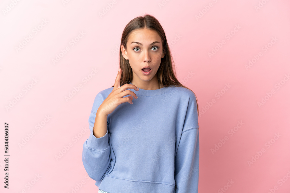 Young woman over isolated pink background intending to realizes the solution while lifting a finger up Young woman over isolated pink background intending to realizes the solution while lifting a finger up