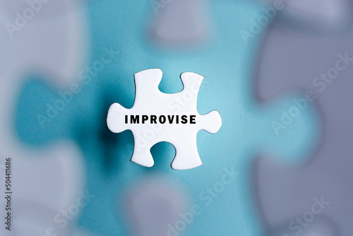 Improvise word on puzzle pieces isolated on blurred blue background.