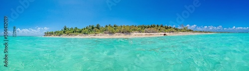 Panorama over a tropical beach taken from the water during the day with sunshine © Aquarius