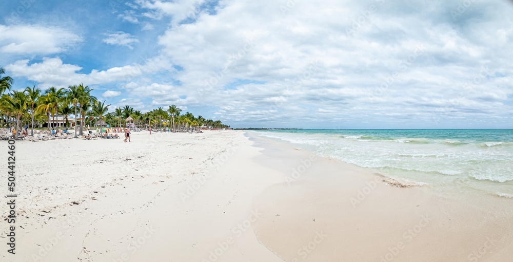 Panorama over a tropical beach taken from the water during the day with sunshine Panorama over a tropical beach taken from the water during the day with sunshine