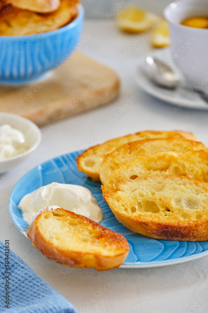 Crushing slices of baguette on a plate with a cup of tea. Crushing slices of baguette on a plate with a cup of tea.