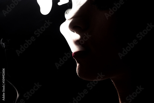 Young young woman in dark smoking cigarette © qunica.com