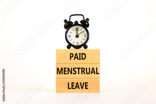 Paid menstrual leave symbol. Concept words Paid menstrual leave on wooden blocks. Black alarm clock. Beautiful white table white background. Business medical paid menstrual leave concept. Copy space.