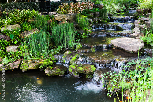 Beautiful fountain with tree in garden.