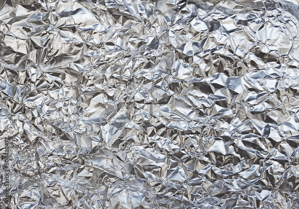 Silver foil with shiny crumpled surface texture background Silver foil with shiny crumpled surface texture background