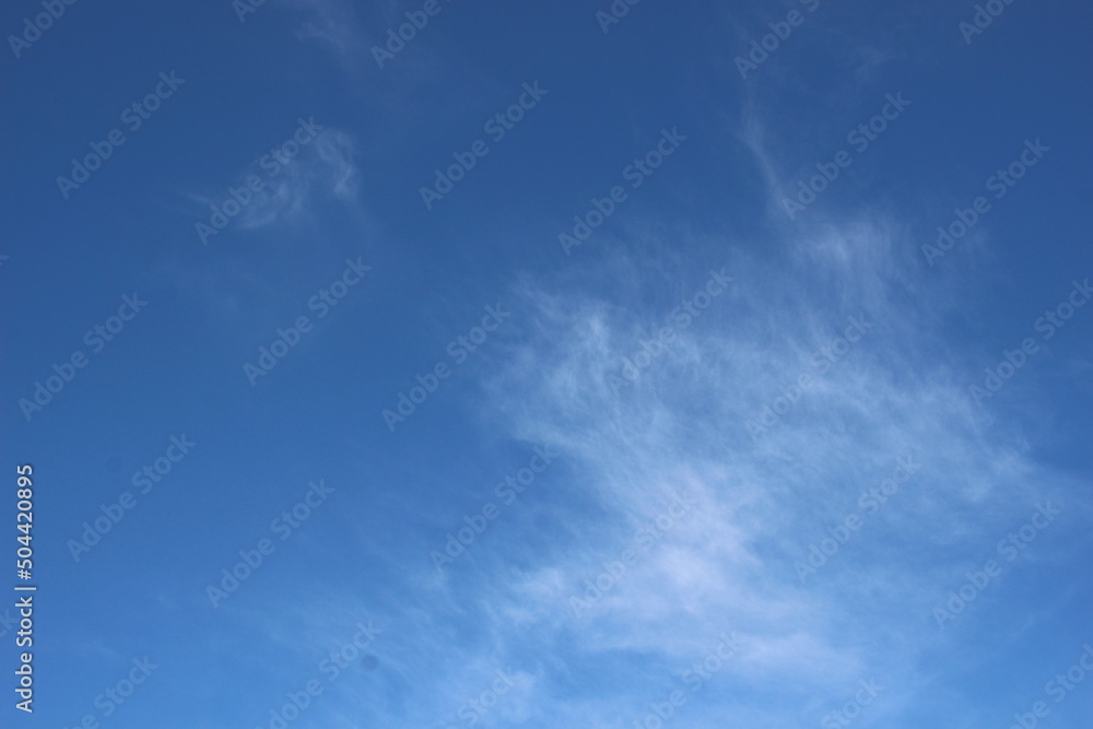 bright blue sky with smoky clouds