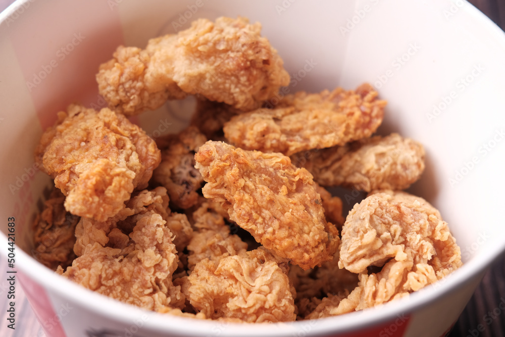 Crispy fried chicken wings in a paper packet on table Crispy fried chicken wings in a paper packet on table