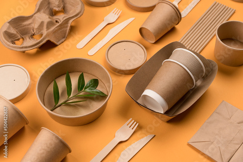 Eco-friendly tableware - kraft paper food packaging on orange background. Street food paper packaging, recyclable paperware, zero waste packaging concept. Flat lay, mockup image