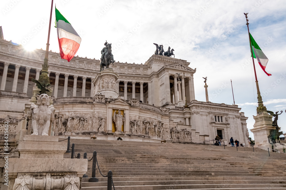 Italian national flag moving in wind with scenic view on front facade of Victor Emmanuel II monument on Piazza Venezia in Rome (Roma), Lazio, Italy, EU Europe. Cityscape of Altar of the Fatherland