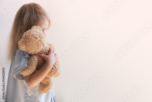 Foto little child, blonde girl 3 years old plays with toy, hugs teddy bear, happy chi