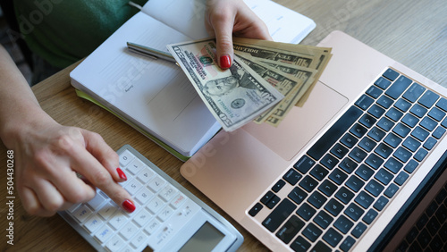 Woman accountant is deducting money using acalculator planning budget photo