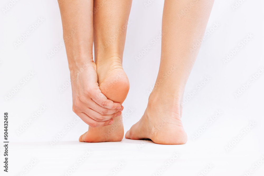 Foot pain from shoes. A young woman holds a sore heel