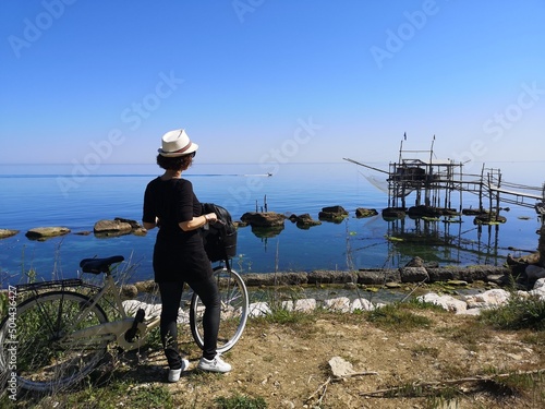 woman with bike on the cycle path of san vito chietino, italy