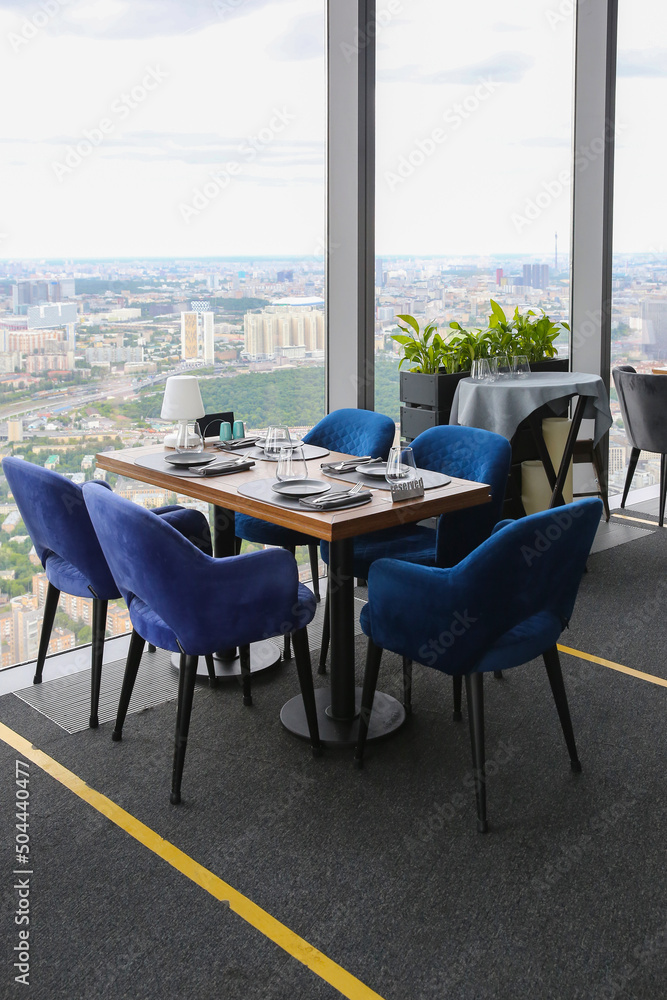 Φωτογραφία A set table in a cafe by the window on the background of a panorama of the city
