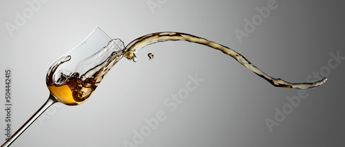 Quadro su tela The drink spills out of the glass.