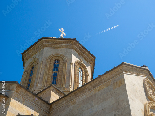 Church of the Holy Trinity. Mount Sameba. Ancient architecture. A beautiful building.  Airplane in the sky on a foen cross photo