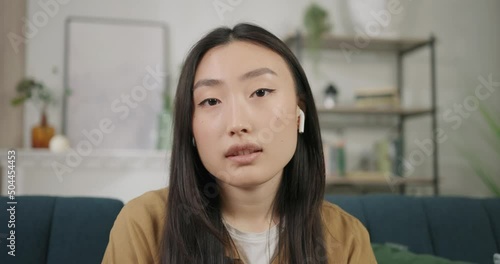 Pretty asian business woman listening talking to webcam make video call at home talking chatting by virtual video call zoom app online video-call meeting. Web camera view. Slow motion