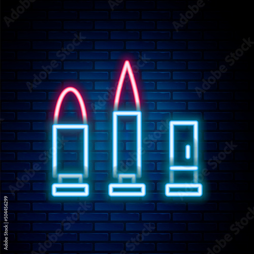 Glowing neon line Bullet and cartridge icon isolated on brick wall background. Colorful outline concept. Vector