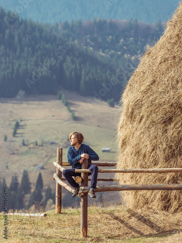 Man sitting on a fence and looking at the mountains around